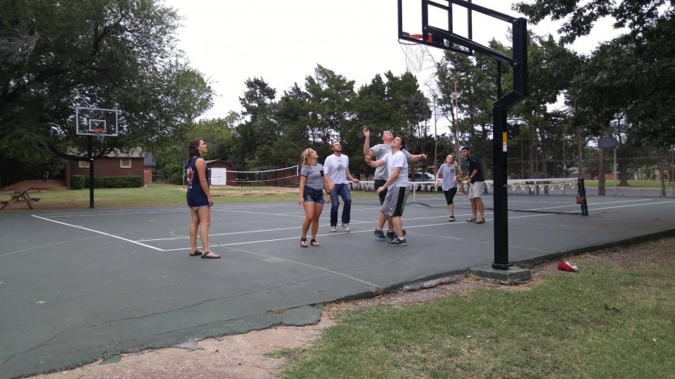 A group of people playing basketball on a court.