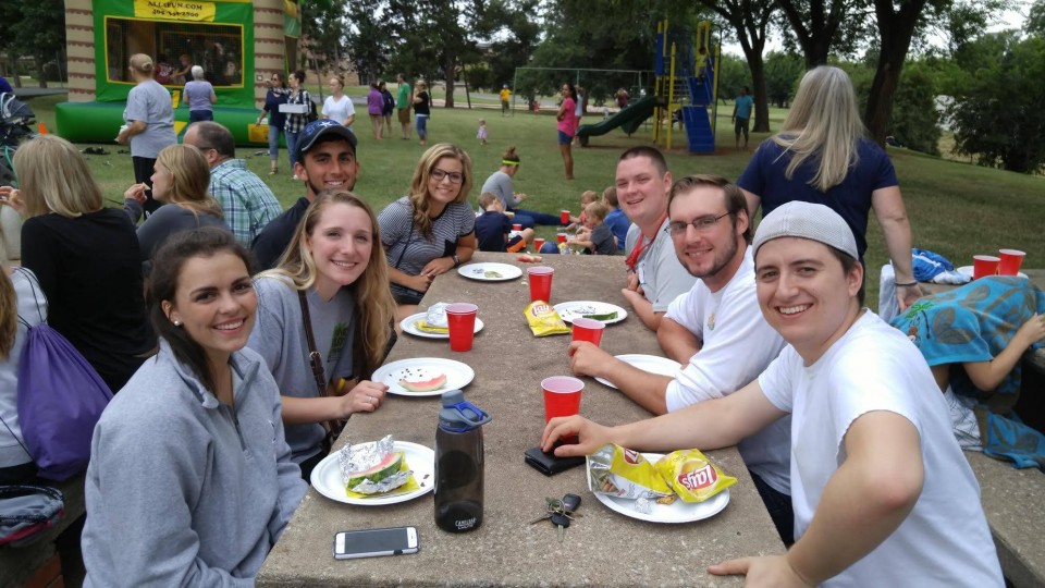 A group of people sitting at a picnic table.