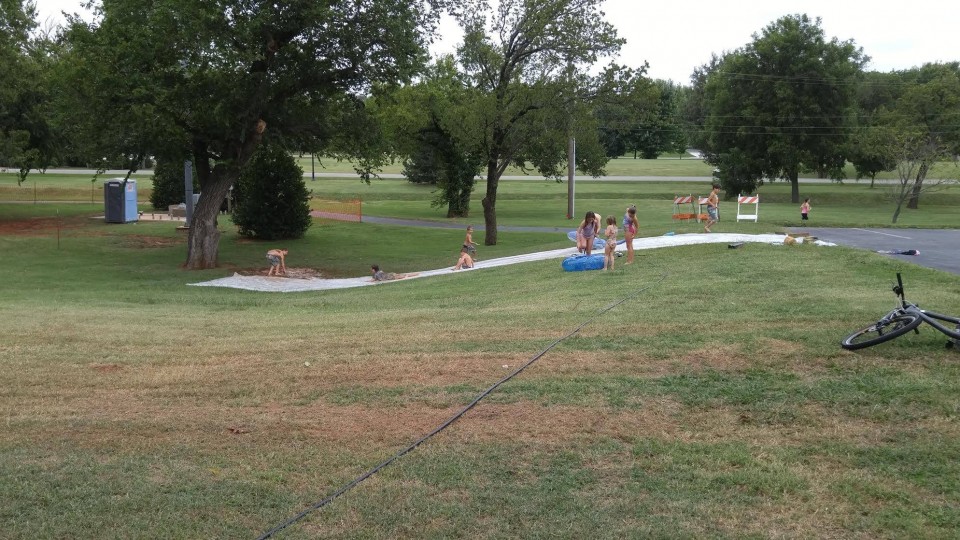 A group of people are sitting on a grassy hill.