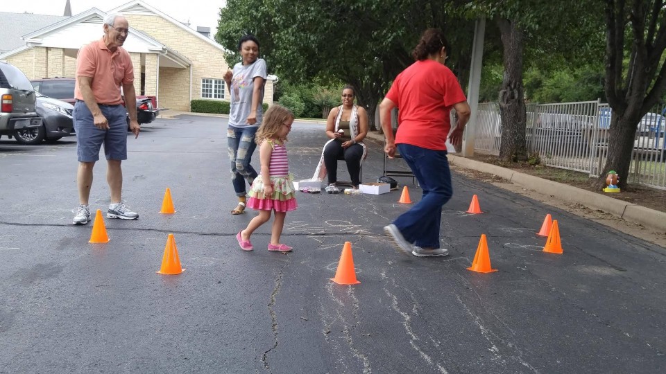 A group of people standing around cones in a parking lot.