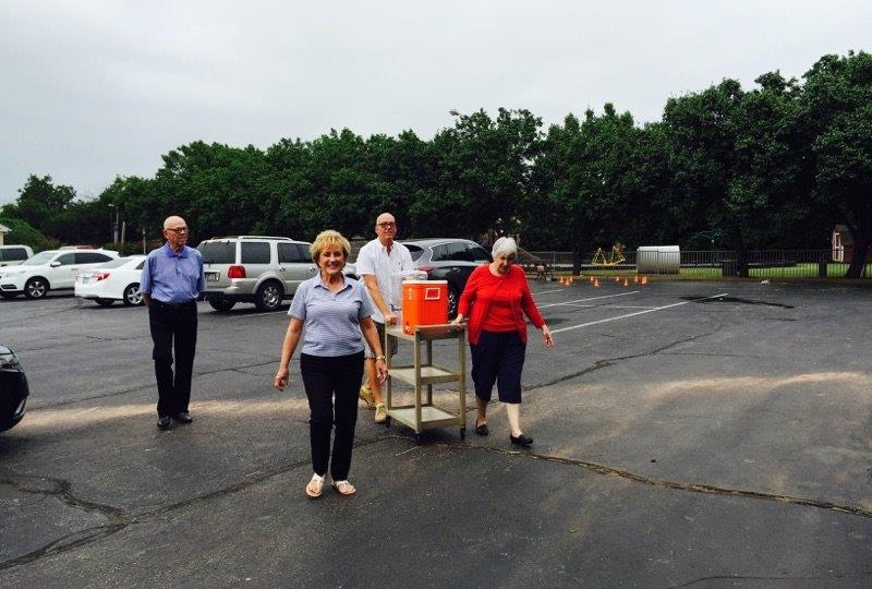 A group of people standing in a parking lot.