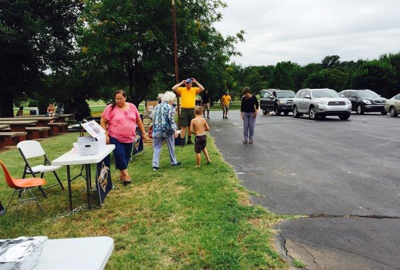 A group of people standing in a parking lot.
