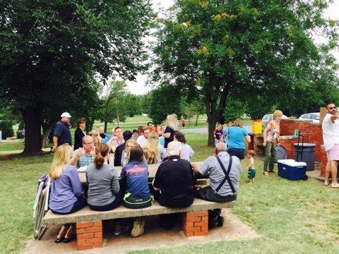 A group of people sitting around a picnic table.
