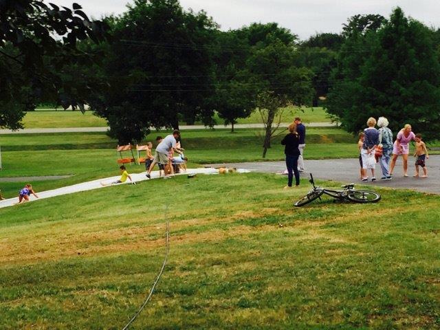 A group of people standing on a grassy area.
