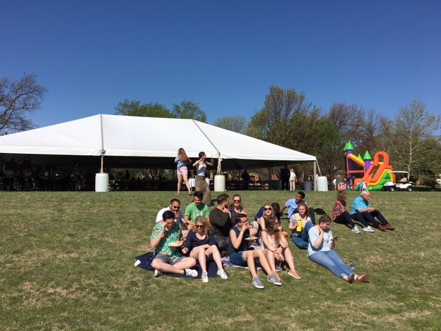 A group of people sitting in front of a tent.