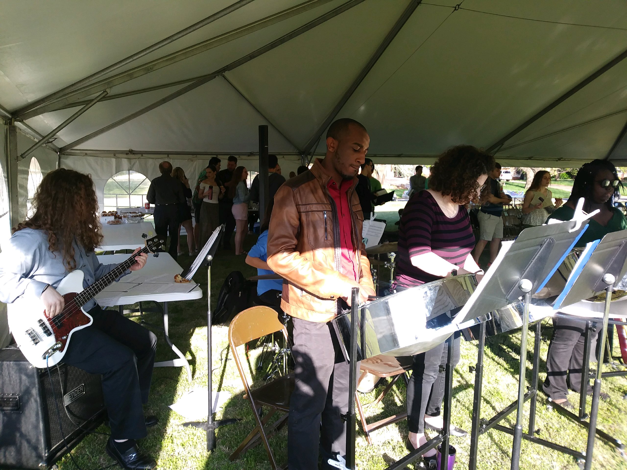 A group of people standing under a tent.