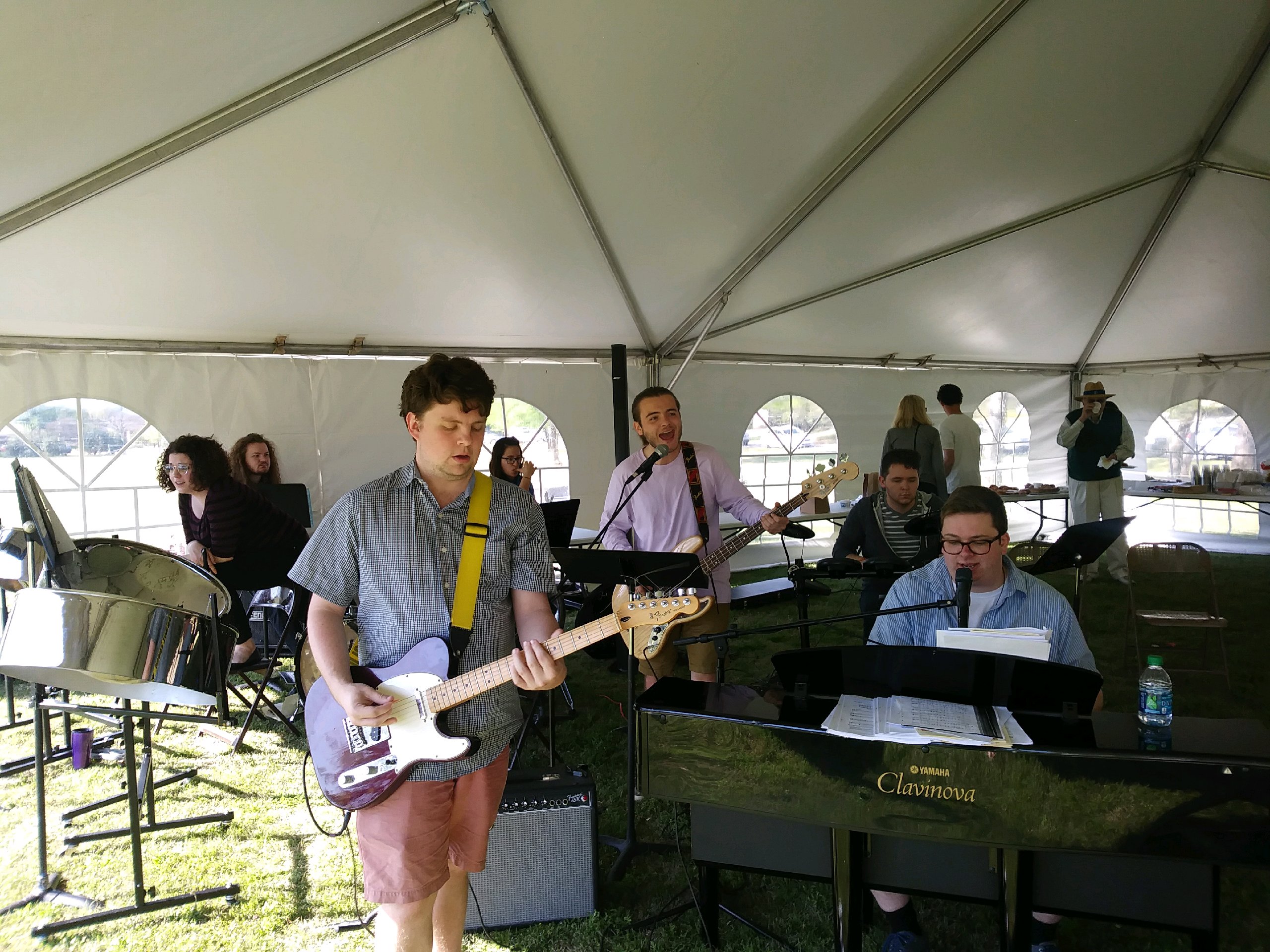 A group of people playing music in a tent.