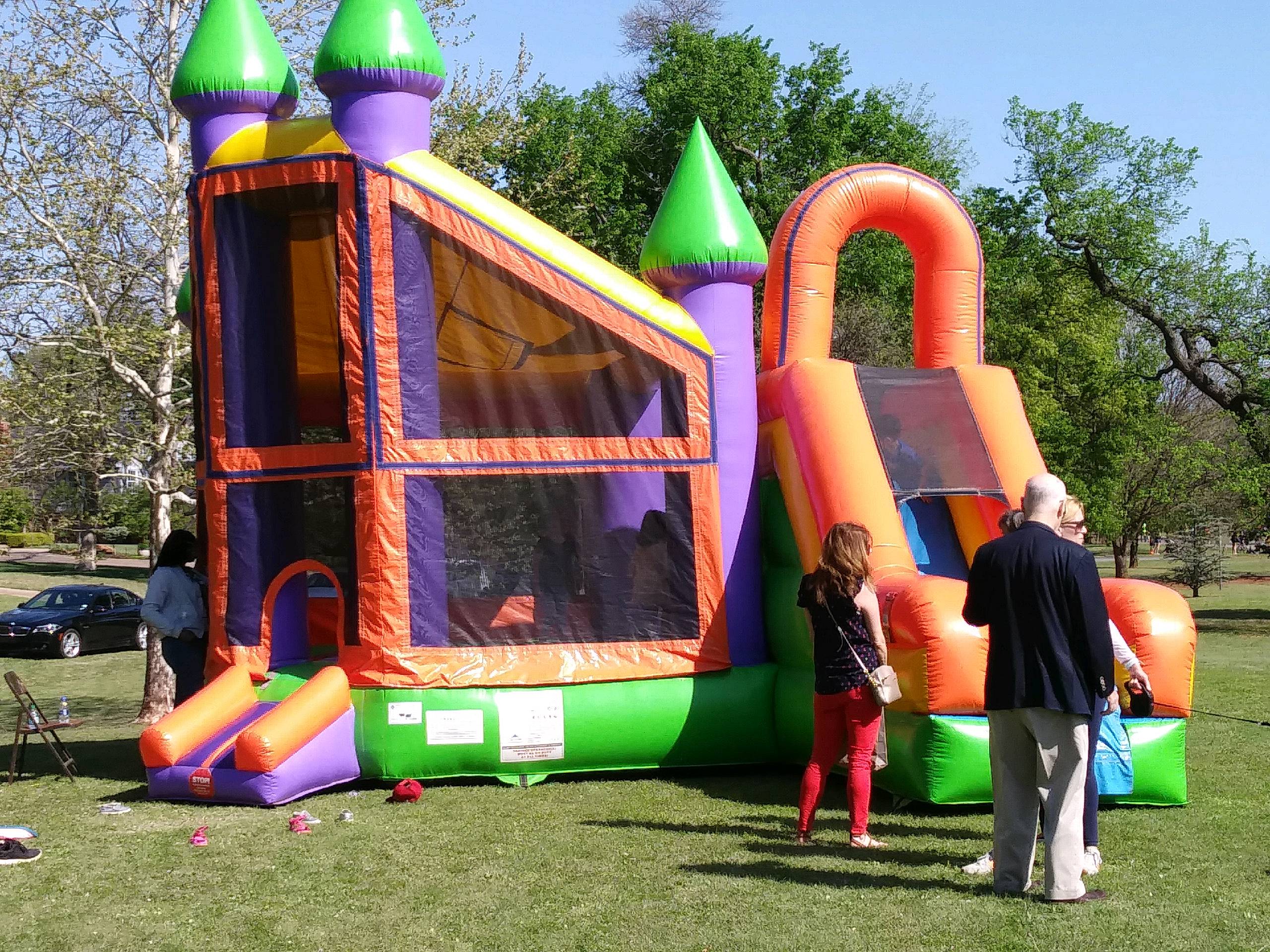 A group of people standing near a bouncy castle.