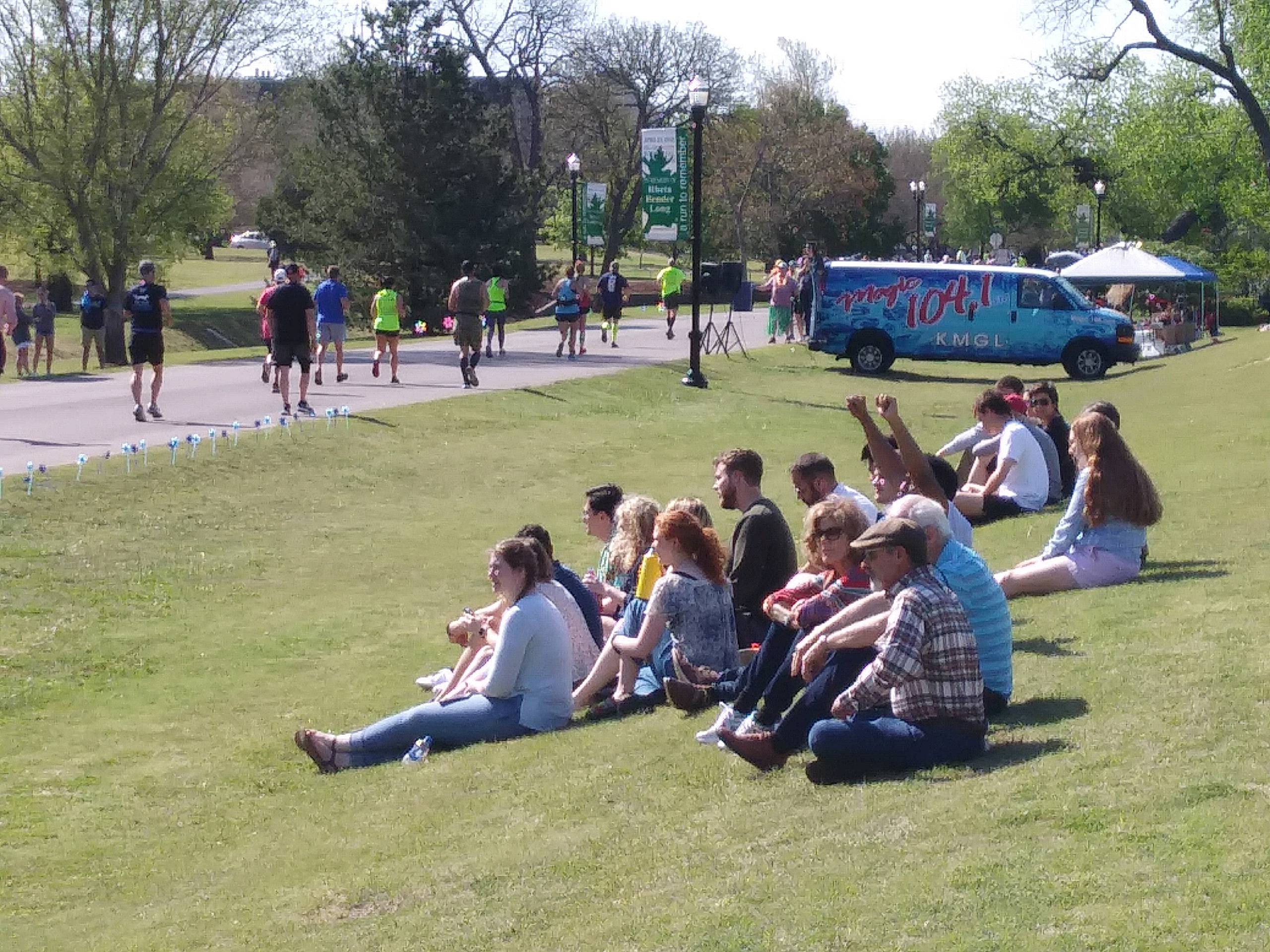 A group of people sitting on the grass.