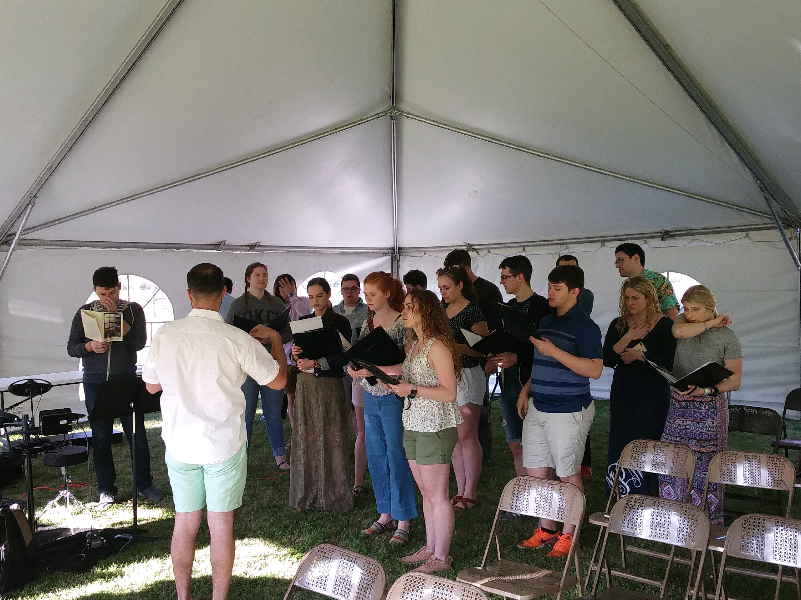 A group of people singing in a tent.