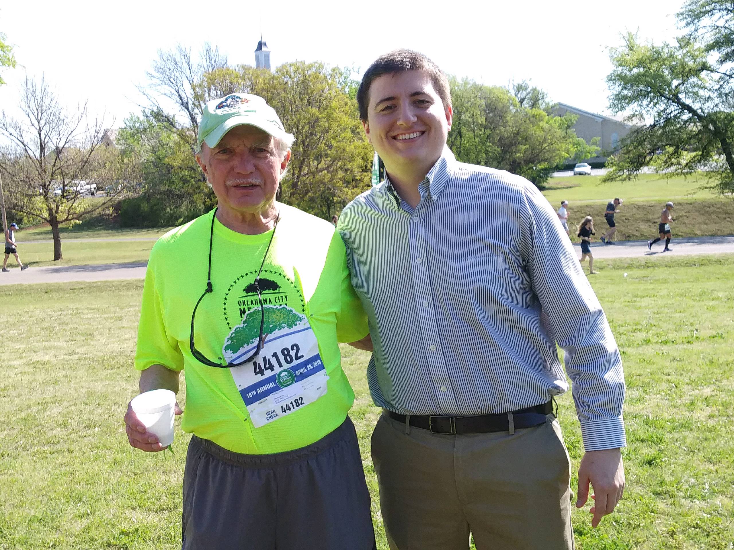 Two men standing next to each other at a race.