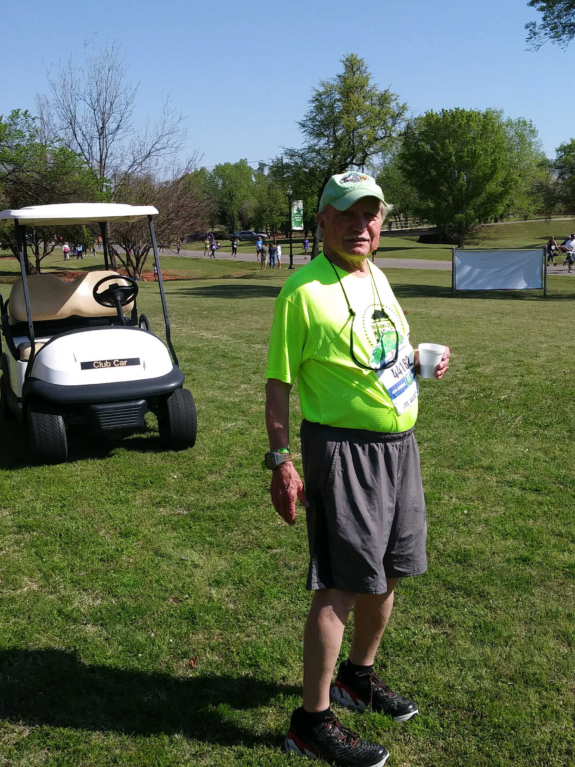 A man standing next to a golf cart.