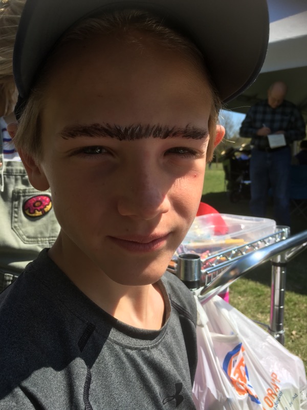 A boy wearing a hat and a hat with eyebrows.