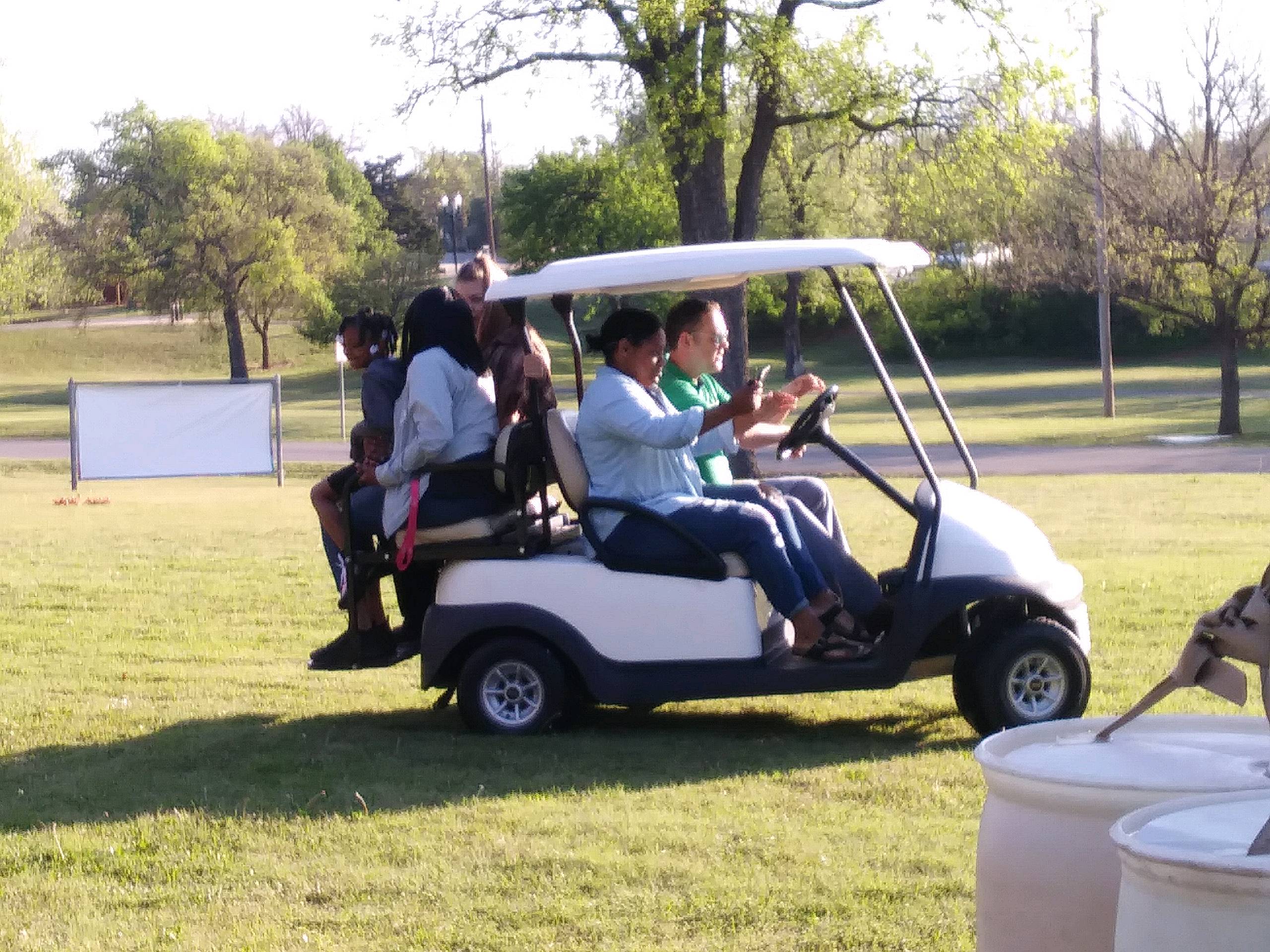 A group of people riding in a golf cart.