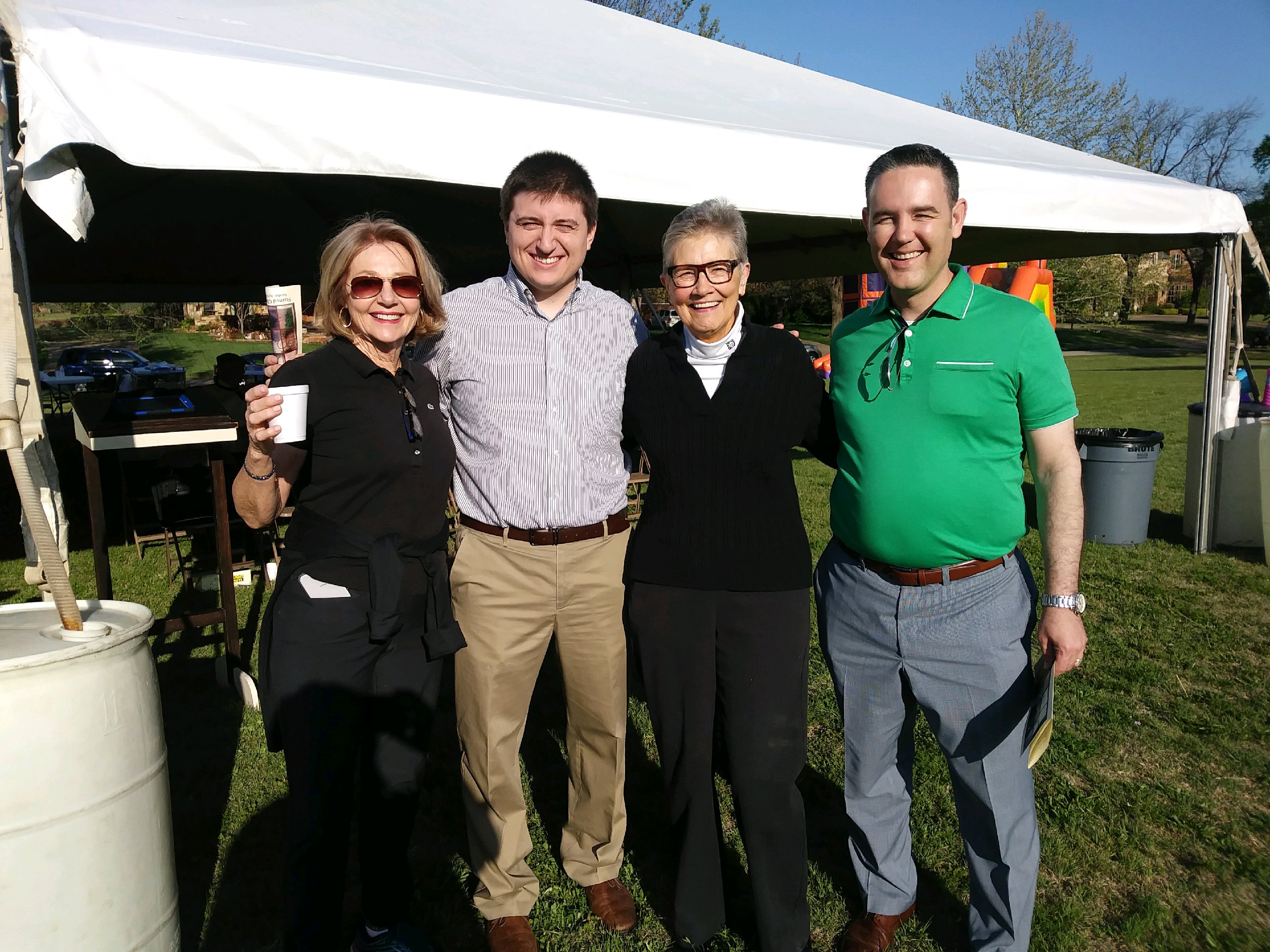 Four people posing in front of a tent.