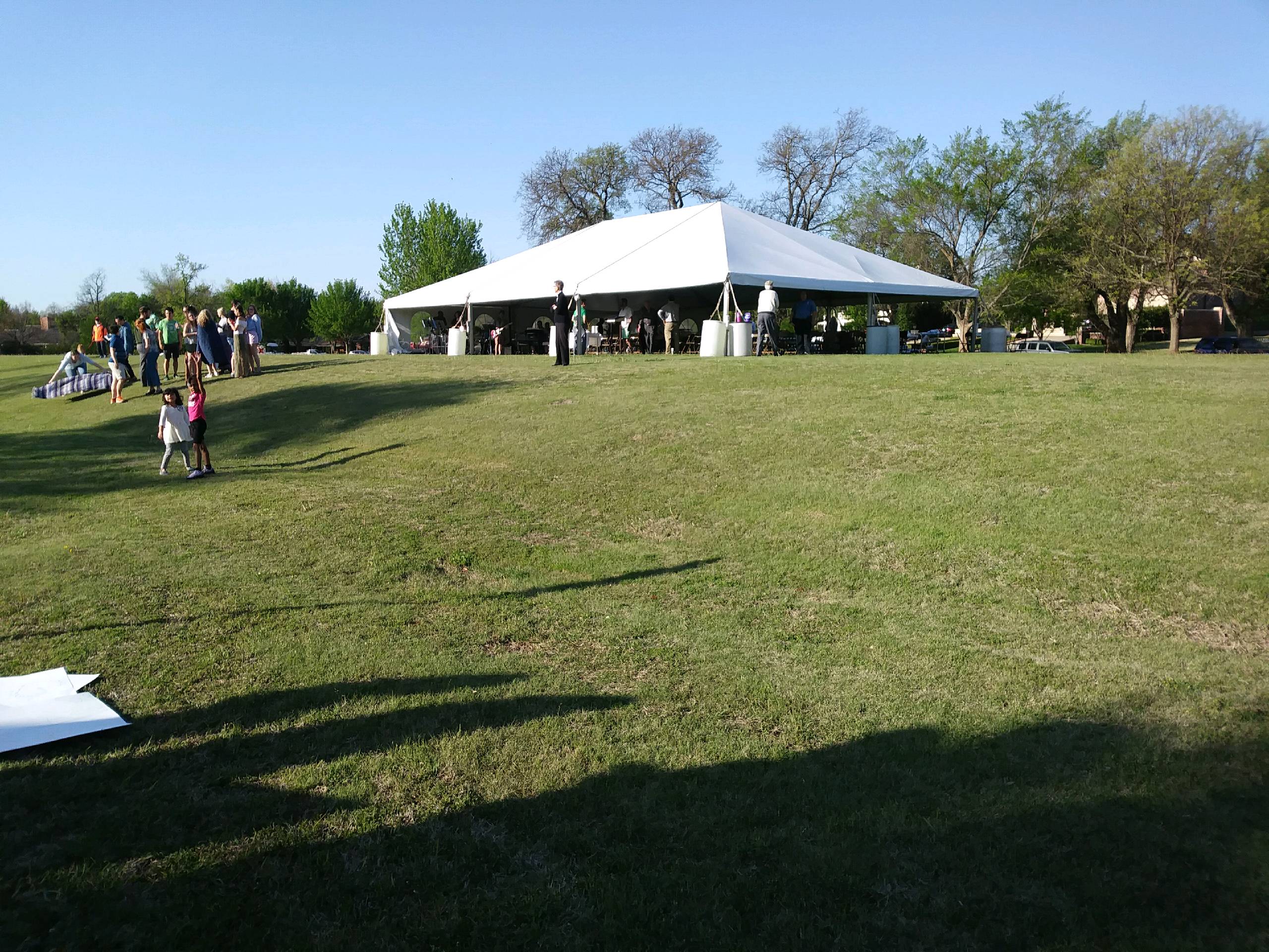 A white tent in the middle of a grassy field.