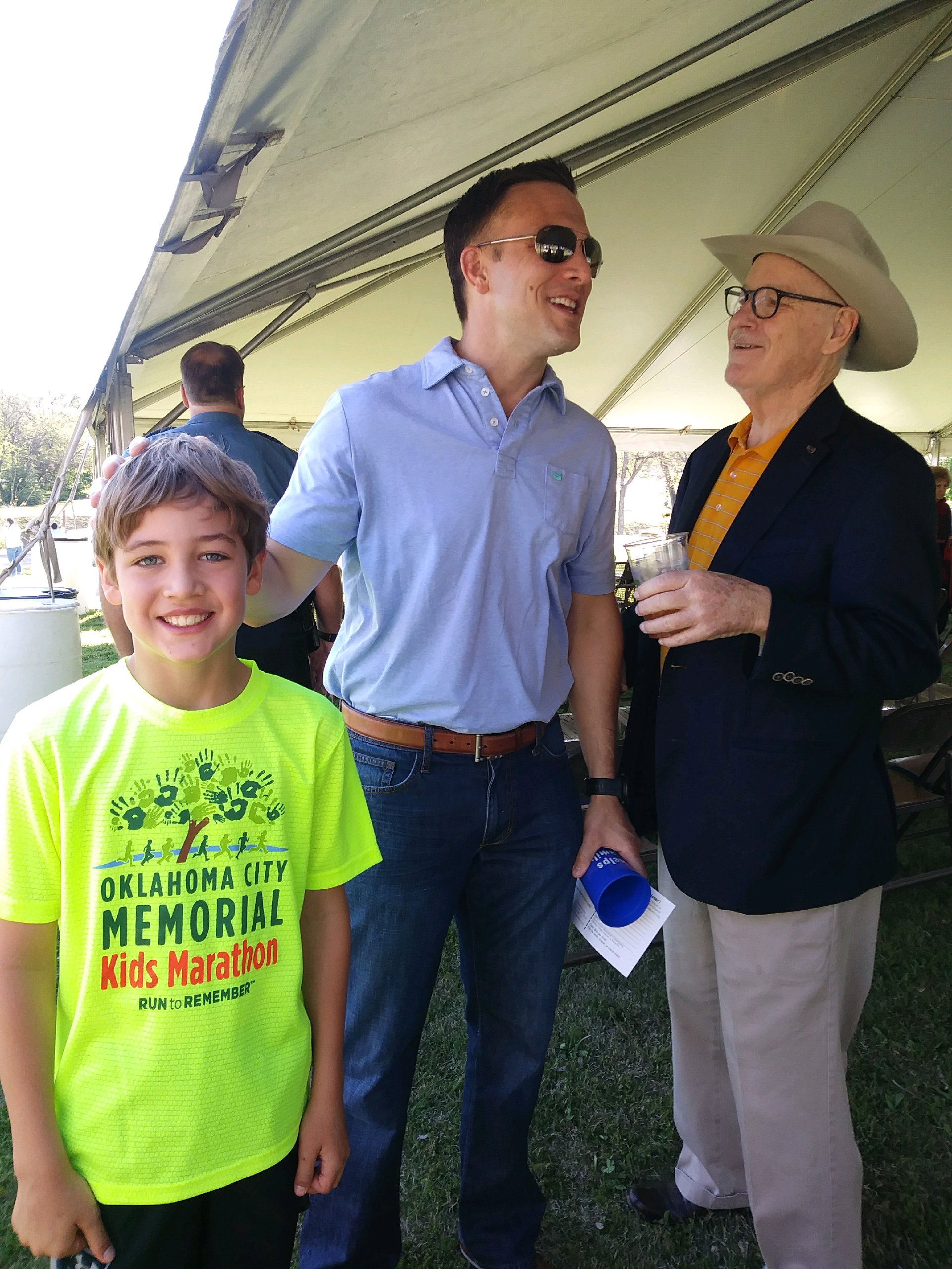 A man and a boy standing under a tent.
