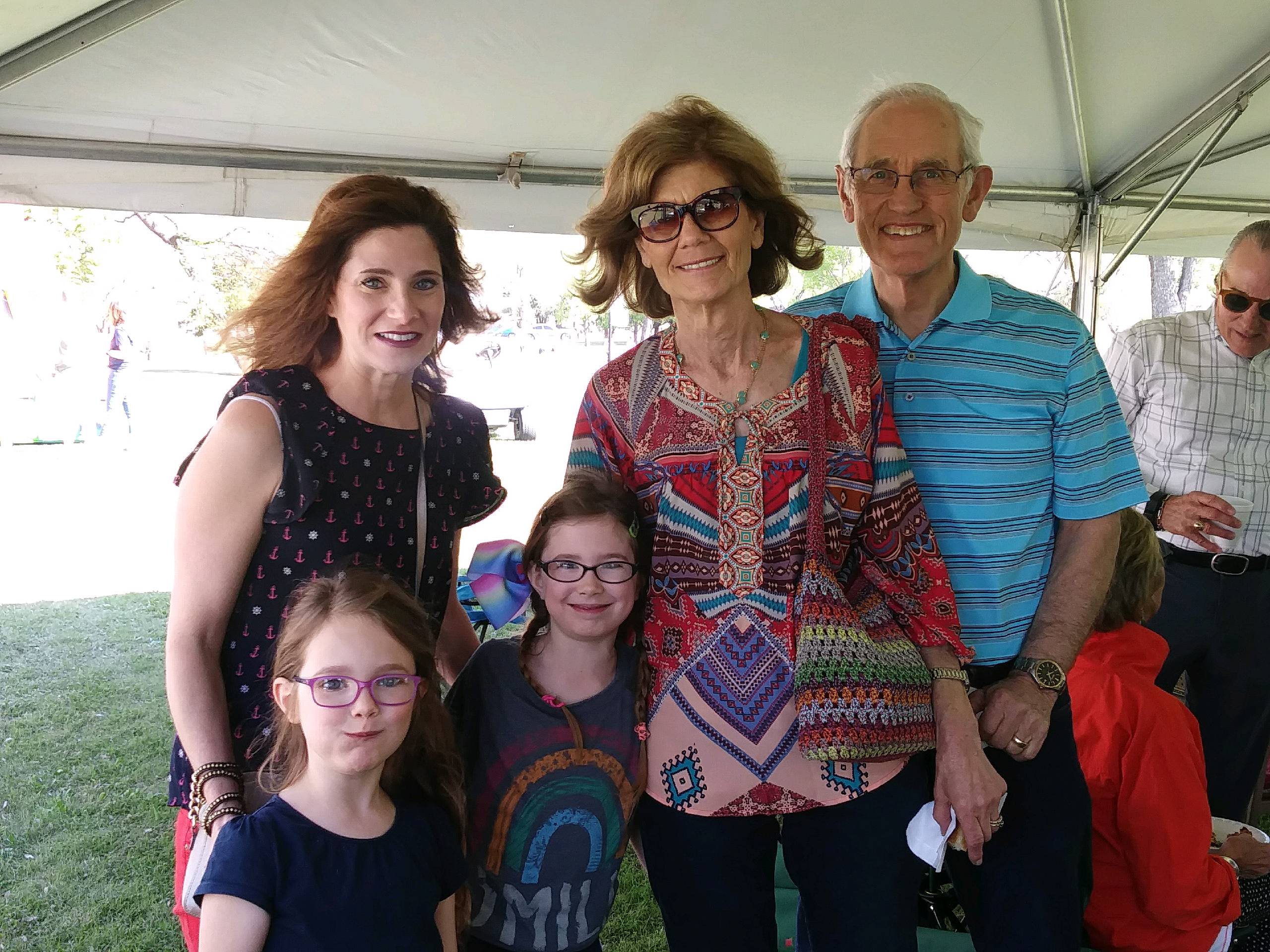 A group of people posing for a picture under a tent.