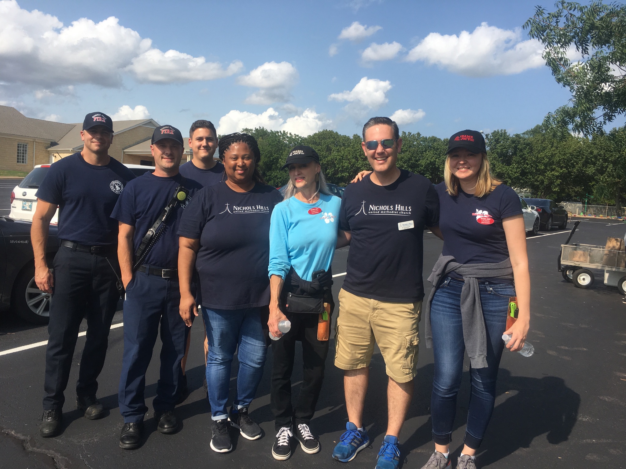 A group of people posing for a photo in a parking lot.