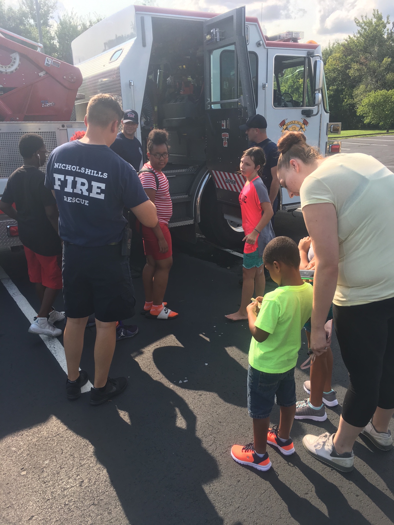 A group of children standing in front of a fire truck.