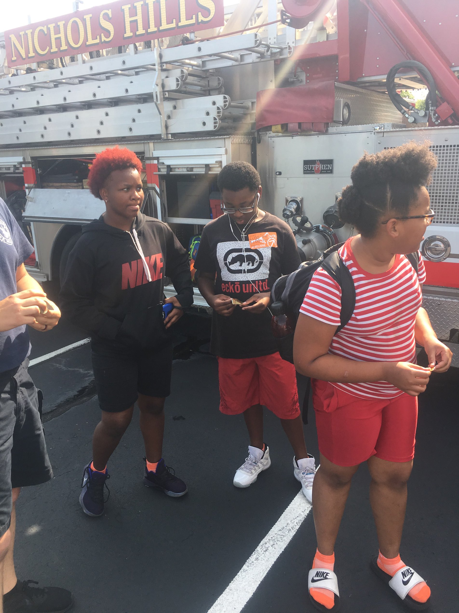 A group of people standing in front of a fire truck.