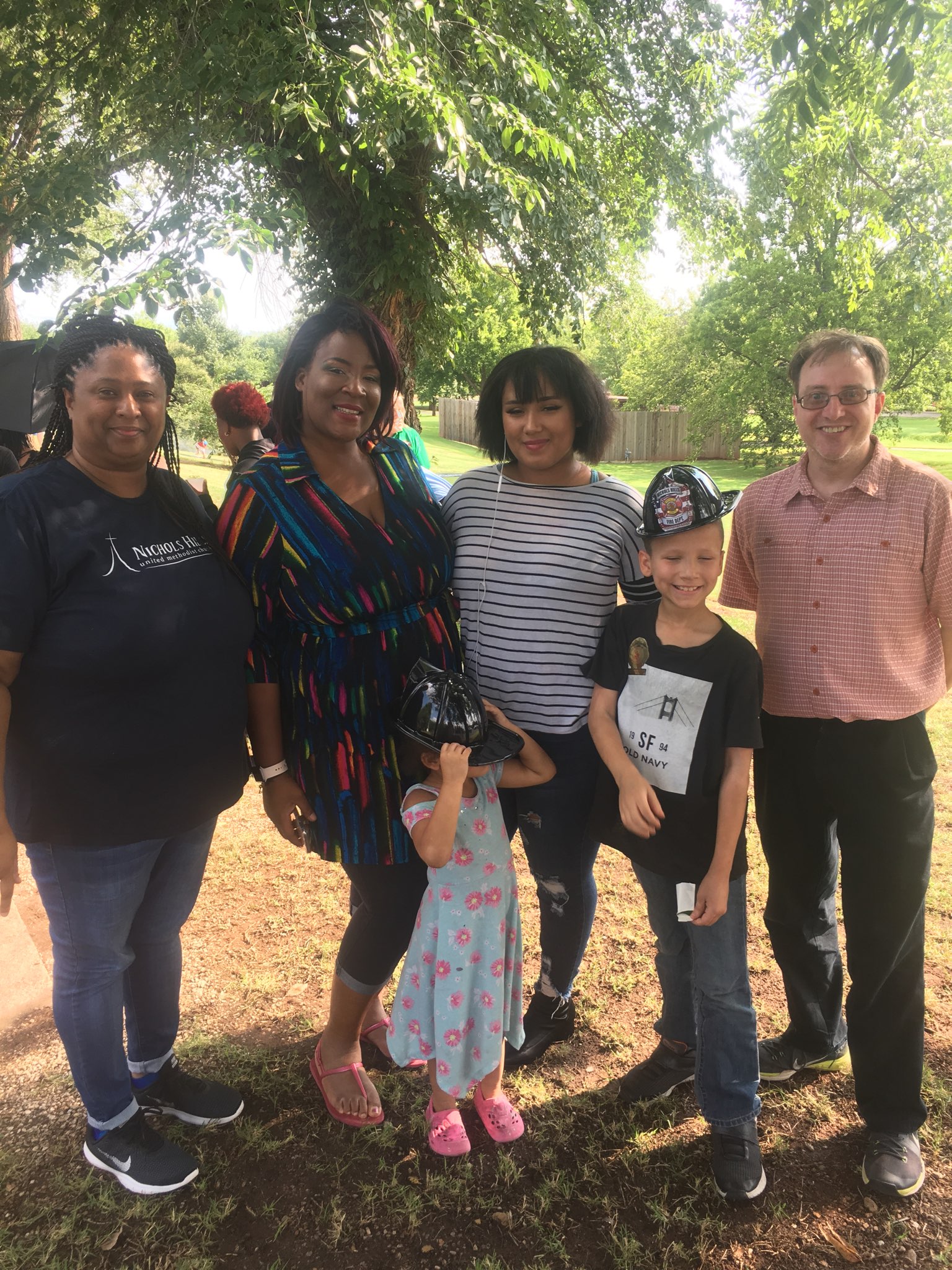 A group of people posing for a picture in a park.