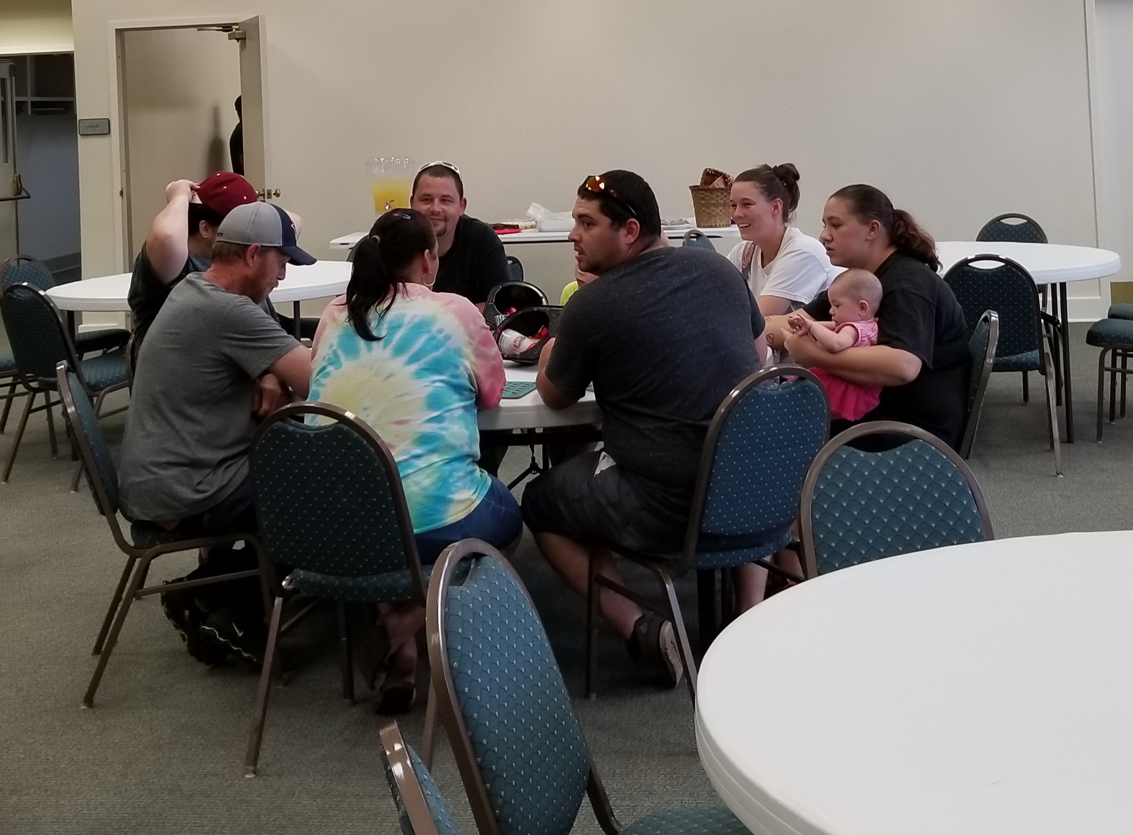 A group of people sitting around a table in a room.