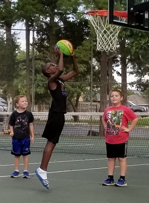 A group of kids playing basketball on a court.