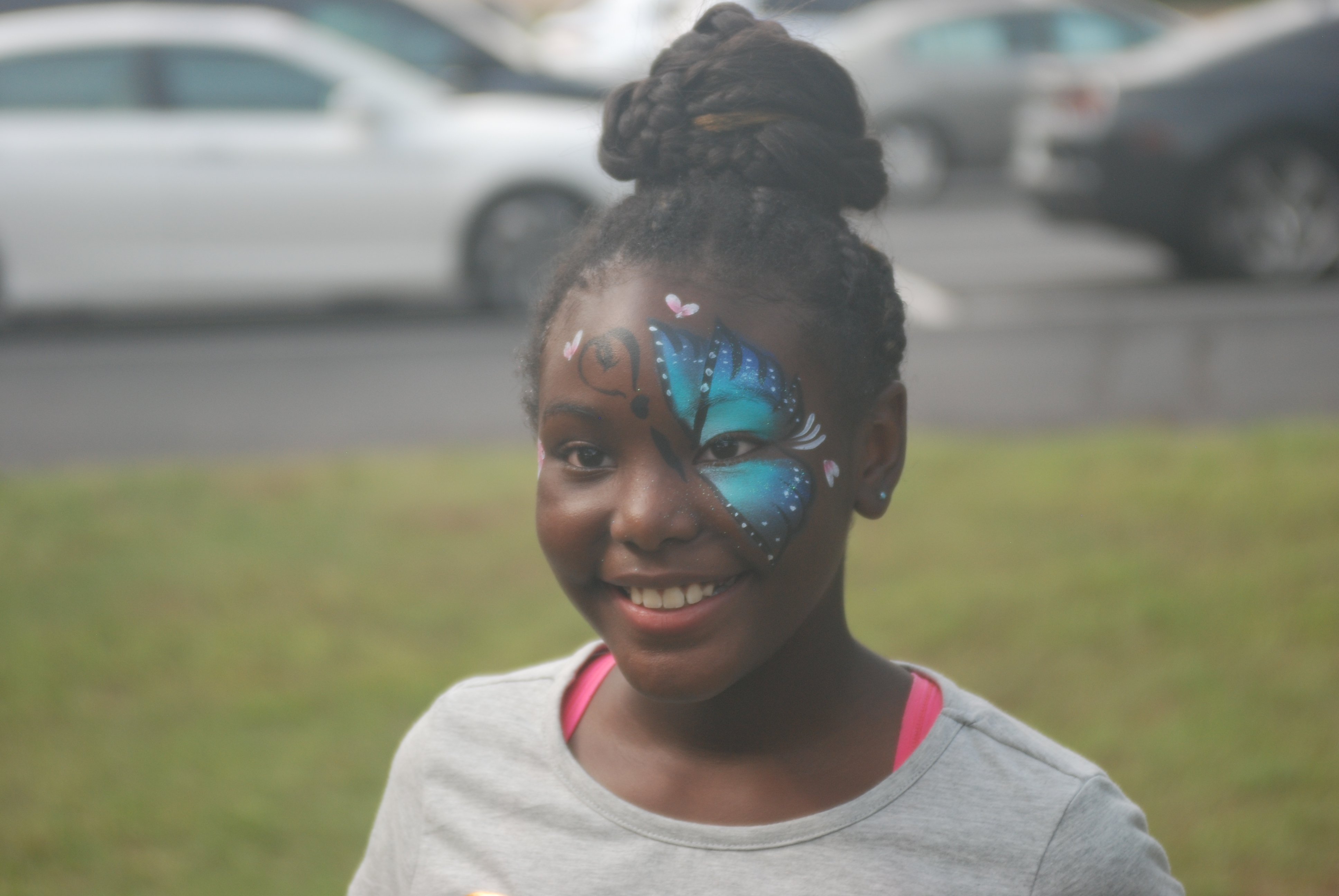 A young girl with a butterfly painted on her face.
