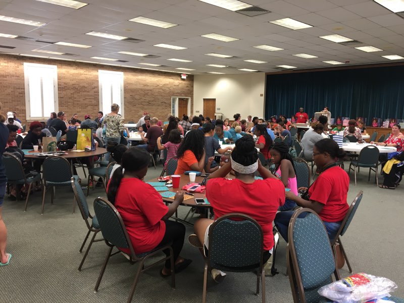 A group of people sitting at tables in a room.