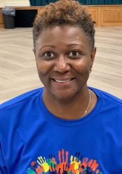 A woman in a blue t - shirt smiling.