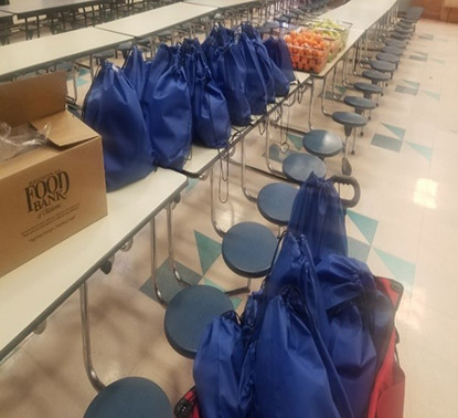 A blue bag sits on a table in a school cafeteria.