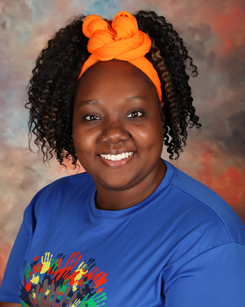 A young woman wearing a blue shirt with an orange headband.